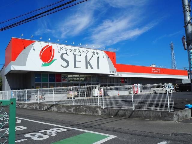 近くのドラッグストアセキ新里店まで450m（徒歩6分）