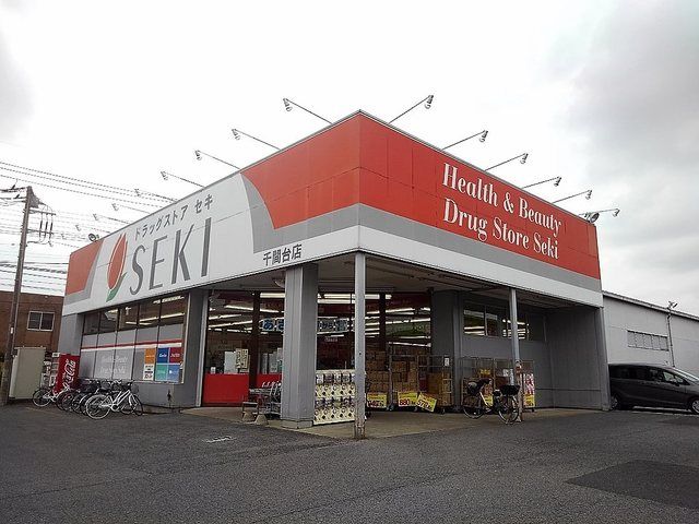 近くのドラッグストアセキ千間台店まで600m（徒歩8分）